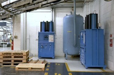two blue balers standing at trivium packaging with pallets in front