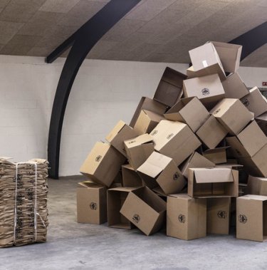 small bale next to a large pile of cardboard boxes highligting that a baler is worth it