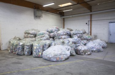 a large pile of clear bags filled with empty pet bottles