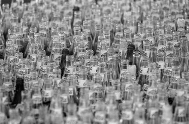 Glass waste pictured as clear, empty glass bottles