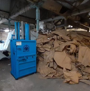 Blue baler and large pile of cardboard at Westieri Beds