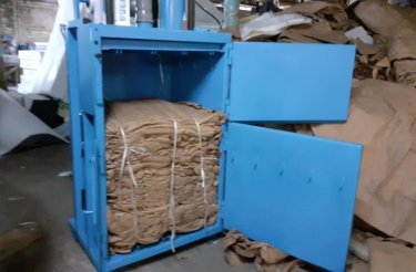 blue baler at westieri beds with open door and cardboard bale inside chamber