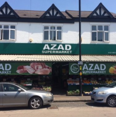 azad supermarket facade and two grey cars in front