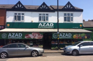 azad supermarket facade and two grey cars in front