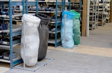 white black blue and green infinity bags on stands at the end of shelfs