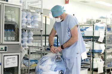 man-in-doctors-clothes-handling-bag-with-hospital-waste