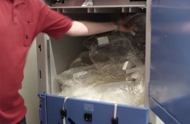 retail-staff-putting-plastic-in-baler