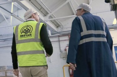 Two men – one wearing a safety vest – conducting a waste audit